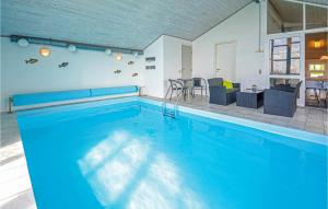 VestervigにあるAmazing Home In Vestervig With 4 Bedrooms, Sauna And Indoor Swimming Poolの大きなスイミングプール(テーブル、椅子付)