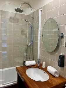 a bathroom with a sink and a shower with a mirror at Hôtel Le Martray in Ars-en-Ré +70 photos