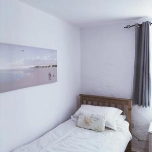 a bedroom with a bed with a picture on the wall at Ballymultimber Cottages in Limavady