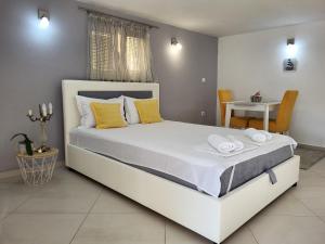 a bedroom with a large white bed with yellow pillows at Apartments Teodo in Tivat
