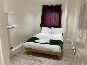 a small bedroom with a bed with a purple window at W3 Guest House in London