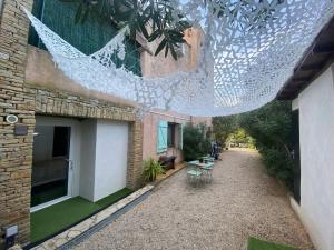 un patio al aire libre con una red colgada de un edificio en STUDIO BIBOUNE, en Ceyreste