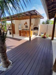 a wooden deck with a kitchen in a house at Casa Harmonia, com 5 suítes em Trancoso-BA in Trancoso