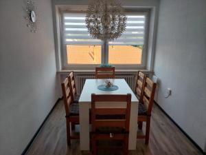 comedor con mesa, sillas y ventana en Ferienwohnung Vorländer en Munster im Heidekreis
