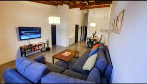 un soggiorno con divano blu e tavolo di Palacios Bari Alojamientos a San Carlos de Bariloche