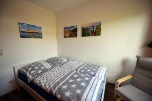 um quarto com uma cama com quatro fotografias na parede em Ferienwohnung Laubegast em Dresden