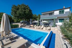 uma piscina com guarda-sol e cadeiras e uma casa em Family Villa Old Garden with heated swimming pool and private tavern em Opanci