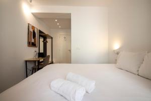 a white bed with white sheets and pillows on it at Old Town Homestay in Donostia-San Sebastián +13 photos