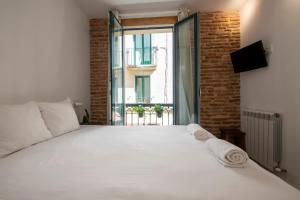 een slaapkamer met een groot wit bed en een raam bij Old Town Homestay in San Sebastian