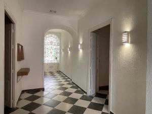 a hallway with a window and a checkered floor at Patios de la Carmela in Isla Cristina