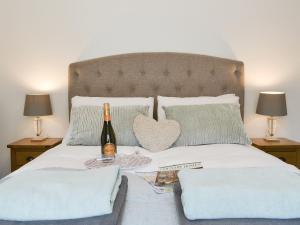 a bed with a bottle of wine and a heart pillow at Bryn Salem in Mallwyd