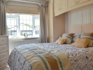 Schlafzimmer mit einem großen Bett und einem Fenster in der Unterkunft Coastal Dream in Burton