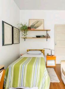 een slaapkamer met een bed met een groene en witte deken bij Beach Apartment in Tel Aviv