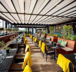 een restaurant met lange tafels en gele stoelen bij Claregalway Hotel in Claregalway