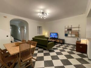 ein Wohnzimmer mit einem grünen Sofa und einem Tisch in der Unterkunft Patios de la Carmela in Isla Cristina