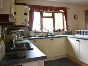 a kitchen with a sink and a stove top oven at Willow Down in Downham