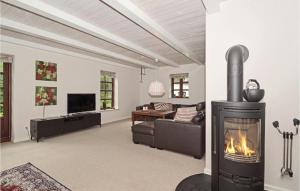 a living room with a fireplace and a couch at 5 Bedroom Stunning Home In Stakroge in Knaplund