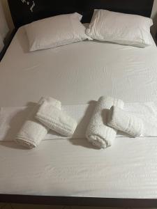 two towels on a bed with white sheets and pillows at CONDOR CENTER TIRANA Apartment in Tirana