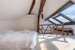 1 dormitorio con cama y ventana grande en Sous Les Toits d'Annecy, un appartement irrésistible pour 1 à 6 personnes en plein coeur de ville, en Annecy