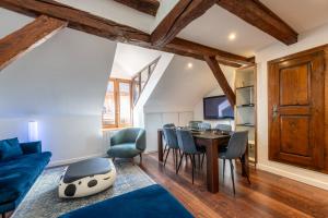 sala de estar con sofá azul, mesa y sillas en Sous Les Toits d'Annecy, un appartement irrésistible pour 1 à 6 personnes en plein coeur de ville, en Annecy