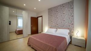 een slaapkamer met een groot bed en een muur bij A casa di Pako in Salerno