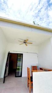 einen Deckenventilator in einem Zimmer mit einem Tisch und Stühlen in der Unterkunft Tiki Bantayan Cebu Tourist Inn Inc in Pooc