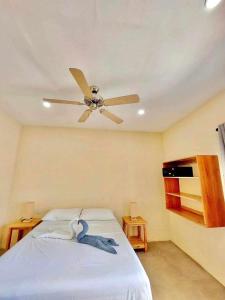 a bedroom with a ceiling fan and a bed at Tiki Bantayan Cebu Tourist Inn Inc in Pooc