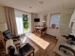 een woonkamer met een bank, een tafel en een bureau bij Bed & Breakfast Inn Drenthe in Fluitenberg
