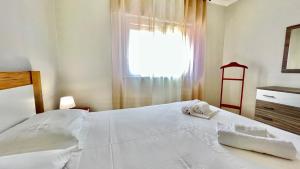 a bedroom with a white bed with towels on it at Surfers Den - One Bedroom Flat - Baleal in Ferrel