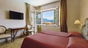 Una habitación de hotel con una cama y una ventana. en Residenza dei Fiori, en Cannero Riviera