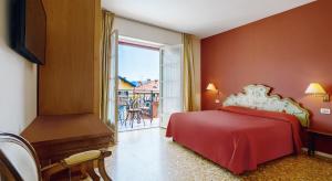 a bedroom with a red bed and a balcony at Residenza dei Fiori in Cannero Riviera