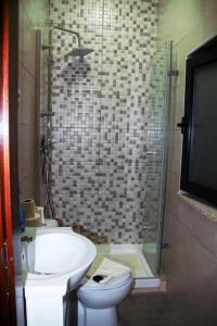 y baño con lavabo, aseo y ducha. en Casa das Matriarcas - Casa da Avó Judite, en Belmonte