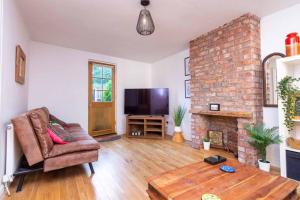 a living room with a couch and a fireplace at Detached house with gated parking in Whalley Range in Manchester