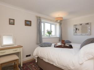 a bedroom with two beds and a desk and a mirror at Crinkum in Titchwell