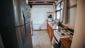 a kitchen with a stainless steel refrigerator and a stove at Sombra Verde in Villa La Angostura +24 photos
