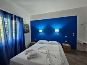 łóżko z niebieskim zagłówkiem z ręcznikami w obiekcie Corfu Dream Holidays Villas Standarts w Korfu