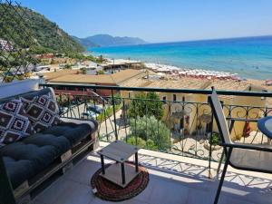 balkon z kanapą i widokiem na plażę w obiekcie Corfu Dream Holidays Villas Standarts w Korfu