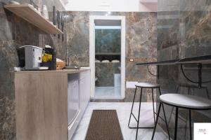 uma cozinha com um balcão e bancos num quarto em MAGIA LUXURY ROOM & SPA em Trecase