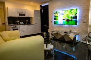 a living room with a tv hanging on a wall at La Duchesse 1976 - Love Room Spa in Vernon