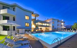 a swimming pool with chairs and a house at Residence with swimming-pool in Marina di Cecina just 700 meters from the beach in Cecina