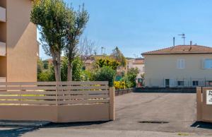 a fence in front of a building with a tree at Residence with swimming-pool in Marina di Cecina just 700 meters from the beach in Cecina