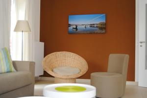a living room with a chair and a tv on the wall at Ostsee Lodges mit Wellnessbereich in Timmendorfer Strand