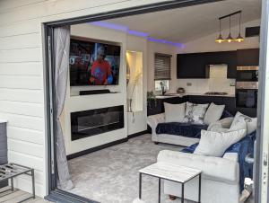 a living room with a couch and a table at Waterside Lodge - Dog Friendly Sutton on Sea in Sutton on Sea