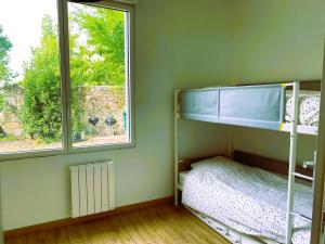 a bedroom with two bunk beds and a window at La troglo aux oiseaux in Montrichard