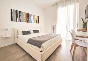 ヴェローナにあるCorte Melone room rentalの白いベッドルーム(大型ベッド1台、デスク付)