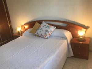 1 dormitorio con 1 cama blanca y 2 lámparas en MAR DE FORA, en Cambados