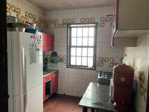 a kitchen with a white refrigerator and a window at Republica Do Arco Da Velha in Ouro Preto