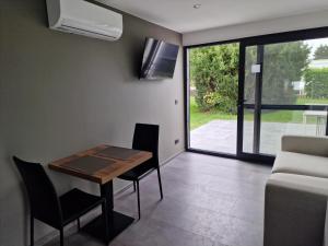 una sala da pranzo con tavolo, sedie e TV di STUDIO - VAKANTIEPARK GROTE ZEEMEEUWEN KOKSIJDE a Koksijde