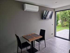 a dining room with a table and chairs and a window at STUDIO - VAKANTIEPARK GROTE ZEEMEEUWEN KOKSIJDE in Koksijde