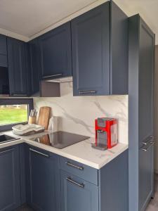 a kitchen with blue cabinets and a red appliance on the counter at STUDIO - VAKANTIEPARK GROTE ZEEMEEUWEN KOKSIJDE in Koksijde